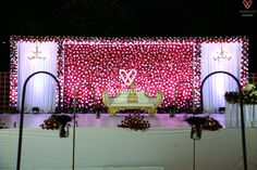 a stage set up for a wedding with flowers on the floor and decorations around it