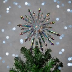 a christmas tree topper is shown in front of snowflakes and sparkles