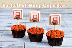 two cupcakes with basketball rings on top of them, one is orange and the other is brown