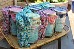 several jars are sitting on a tray with fabric wrapped around them and tied to each other