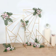 three gold geometric frames with flowers and greenery