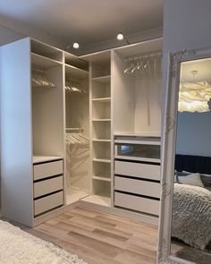 an empty bedroom with white closets and wooden flooring is pictured in this image