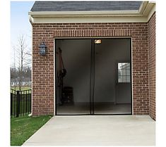 an open garage door in front of a brick building