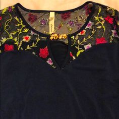 Beautiful Navy Blue Blouse With Sweetheart Neckline. Made Of Soft Flowy Material. Floral Embroidery On Soft Net Material. Pearl And Stone Embellished Pin. Blue Blouse With Floral Embroidery For Party, Festive Blue Top With Floral Embroidery, Elegant Multicolor Embroidered Festive Tops, Elegant Festive Tops With Multicolor Embroidery, Blue Embellished Long Sleeve Top, Blue Festive Tops For Spring, Blue V-neck Tops For Festive Occasions, Blue Embellished V-neck Top, Embellished Blue V-neck Top