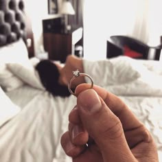 a person is laying in bed with a ring on their finger