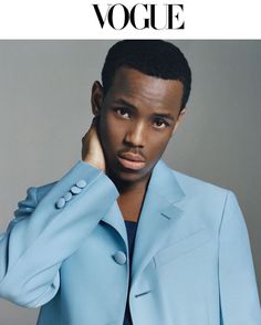 a man in a blue suit is posing for the cover of a magazine with his hand on his head