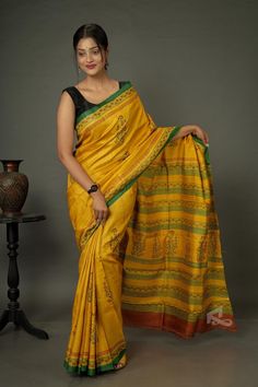 The auspicious colors make this handwoven Gachi Tussar yellow saree the perfect wedding or reception wear. The woodblock prints are a testimony of the works of skilled artisans. Its elegance makes it the go-to saree for special occasions. At Ramdhanu Ethnic, we call it a timeless fashion. You can conquer any adversity by draping this yellow saree. Remember, the essence of it hasn't changed and the charm of the fabric still remains.   What makes this saree special is the almost magical process of weaving it. The history of Tussar silk is a beautiful chapter in the history of Indian textiles. The process is much more complex and involves many unique tools that look primitive but work like magic. Tussar silk shares the history with the raw silk and is rooted in medieval times. In Sanskrit, it Luxury Tussar Silk Saree With Tilla, Transitional Yellow Chanderi Pre-draped Saree, Bollywood Style Yellow Pre-draped Saree For Transitional Season, Transitional Season Yellow Pre-draped Saree, Yellow Pre-draped Saree For Transitional Wedding Season, Yellow Cotton Silk Blouse Piece With Pallu, Yellow Semi-stitched Pre-draped Saree For Transitional Season, Transitional Yellow Semi-stitched Pre-draped Saree, Transitional Semi-stitched Yellow Pre-draped Saree