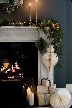 a fireplace decorated with christmas presents and candles