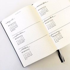 an open notebook with a calendar and pen on the cover, sitting on a table