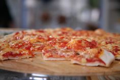 a pizza sitting on top of a wooden cutting board