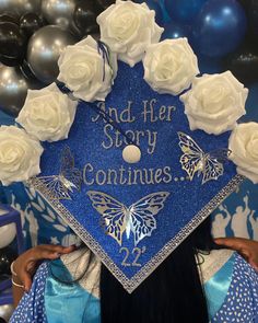 a woman wearing a blue graduation cap with white roses on it and the words end her story continues