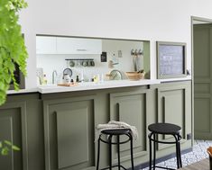 two stools are in front of the bar with an open sink and mirror on the wall