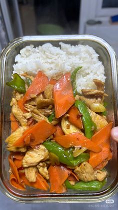 a container filled with rice and vegetables on top of a table