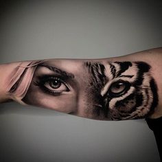 a woman's arm with a tiger face on it and an eye in the middle