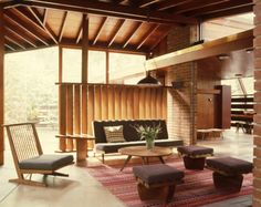 a living room filled with lots of furniture and wooden beams on top of the ceiling