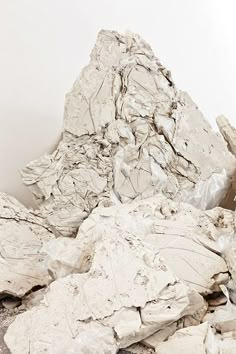 a pile of rubble sitting on top of a floor next to a white wall with a red fire hydrant