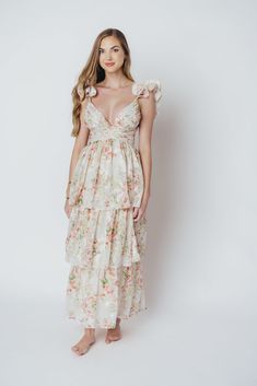 Crafted from a luxe, lightweight fabric adorned with delicate flowers, this ethereal maxi dress is a romantic dream come true. The sumptuous ruffles and open back create a charming silhouette that will leave you feeling like a princess. FIT: Runs small, and fabric is not stretchy. Please refer to size chart. MATERIAL: 100% Polyester. GARMENT DETAILS: Floral print maxi dress with a plunging neckline, fluttery ruffled straps, and empire waist. Features a ruffled hem, open back with crisscross self-tie detail, and invisible zipper in the back. MEASUREMENTS: Size Length Bust Waist Small 54" 29" 27" Medium 54" 31" 29" Large 54" 33" 31" SIZE GUIDE: S (2-4) / M (6-8) / L (10-12) MODEL DETAILS: Heather is wearing a size S. Mackenzie - Size S Heather - Size S Molly - Size XL Our Brunette Misses Mod Feminine Midi Dress For Garden Party, Feminine Maxi Dress With Ruffled Straps For Beach, Flowy Floral Print Midi Dress With Ruffled Straps, Flowy Floral Midi Dress With Ruffled Straps, Flowy Maxi Floral Dress With Smocked Back, Floral Ruffled Maxi Dress For Party, Ruffled Maxi Dress For Garden Party, Maxi Length Dresses With Smocked Back For Garden Party, Maxi Dress With Smocked Back For Garden Party