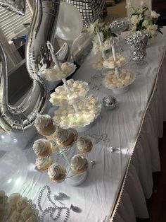 a table topped with lots of cupcakes and cakes