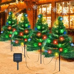 christmas trees are lined up in front of a store with lights on them and snowflakes all around