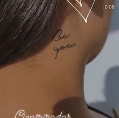 the back of a woman's neck has a tattoo that reads, be you