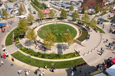 an aerial view of people walking around a circular area in the middle of a city