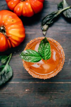 an orange cocktail garnished with fresh basil