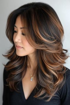 She has longwavy hair with lots of bodyHer dark locks are enhanced by softwarm highlights that blend in naturallygiving her hair a beautifuldimensional lookClick to see more of Gorgeous Low-Maintenance Brunette Balayage Looks for Every Occasion and follow us for more hairstyle ideas.