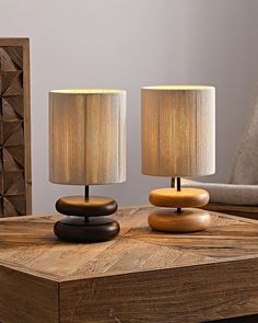 two lamps sitting on top of a wooden table