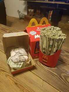 a box full of money sitting on top of a wooden table next to a mcdonald's sign