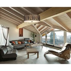 a living room filled with lots of furniture next to a large open floor plan window