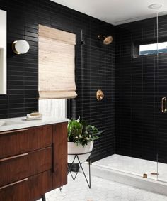 a bathroom with black tile and wooden accents