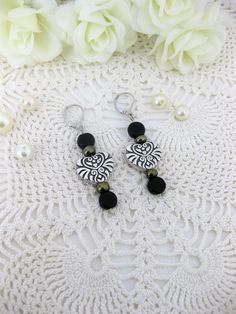 Woman's black and silver heart beaded Earrings handmade by Ralston Originals. Two styles of black earrings to choose from. One pair of earrings are on silver metal lever back earrings. They have beautiful large antique silver designed hearts, and include black glass beads, and antique black beads. The other pair of earrings are on silver metal fish hook earrings. They have large antique silver metal square beads with a fancy detail. They have black glass beads, and silver metal beads. These earr Handmade Black Dangle Heart Earrings, Handmade Black Heart Dangle Earrings, Black Heart Earrings With Ear Wire, Black Heart-shaped Earrings With Hooks, Heart-shaped Black Earrings, Handmade Black Heart Earrings, Elegant Adjustable Heart Beads Earrings, Elegant Heart Beads Earrings, Heart Beaded Earrings