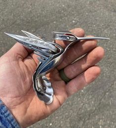 a person is holding some metal scissors in their hand and it looks like they are flying