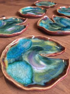 several blue and green plates sitting on top of a wooden table