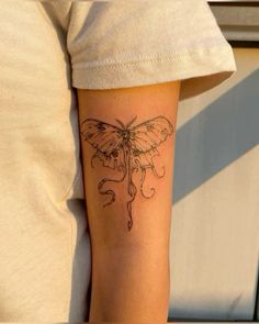 a small tattoo on the arm of a person with a butterfly on it's back