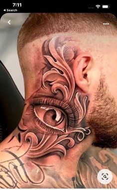 a man's neck with an eye tattoo on it