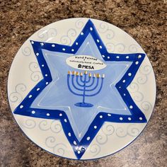 a blue and white plate with a lit menorah on it