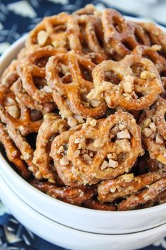 a white bowl filled with pretzels on top of a blue and white table cloth