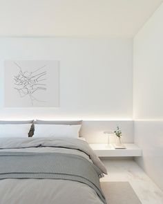 a bedroom with white walls and grey bedding, along with a painting on the wall