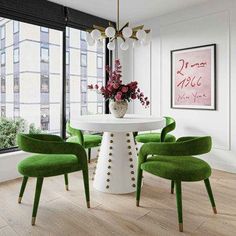 a dining room with green chairs and a white table in front of a large window