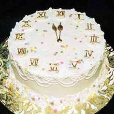 a cake with white frosting decorated with gold letters and numbers on the bottom layer