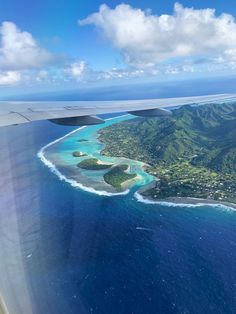 an aerial view of the ocean and land from a plane flying in the blue sky