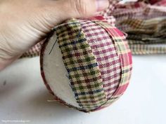 someone is sewing on a fabric ball