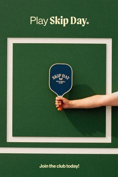 a ping pong paddle being held up against a green background that says play skip day join the club today