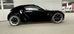 a black sports car parked in front of a garage