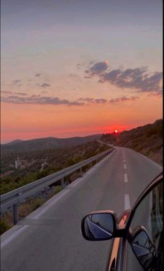 the sun is setting on an empty highway