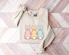 Pastel Bunnies Sweatshirt, Easter Sweatshirt, Easter Bunnies Sweatshirt, Easter Gift, Happy Easter Shirts, Easter Bunny Sweatshirt For Woman Thank you for shopping with us❤️ Size - Our products are unisex fit - You can check our size and color charts on our listing photos. How To Order - Select a size - Select a t-shirt color - If available, indicate the design (text) color in the personalization box - Click add to cart. You can go back to add more shirts. - Click "Proceed to check out". Care In Cute Crew Neck Top With Bunny Design, Cute Multicolor Crew Neck Sweatshirt, Cute Crew Neck Easter Tops, White Bunny Print Crew Neck Top, White Crew Neck Tops With Bunny Print, White Crew Neck Top With Bunny Print, Cute Long Sleeve T-shirt As Gift, White Crew Neck Top For Easter, Cute Long Sleeve Tops As Gift