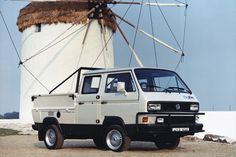 a white truck parked in front of a windmill