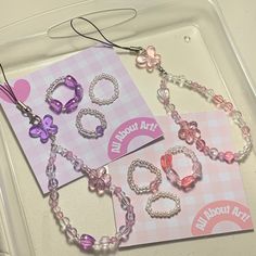 two pink and purple bracelets are on a plastic tray next to a greeting card