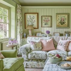 a living room filled with lots of furniture and flowers on the wall above it's windows